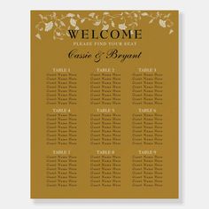 a gold and white wedding seating chart with leaves on it, sitting on top of a table