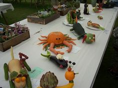 there are many vegetables on the table with fruit and vegetables in front of them, as well as an octopus