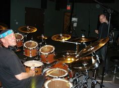 a man sitting in front of a drum set