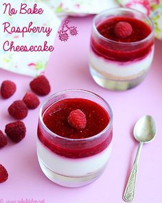 raspberry cheesecake in small glass jars with spoons on pink tablecloth