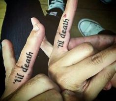 two people holding up their fingers with words on them