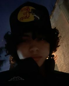 a person wearing a hat with a sticker on it's cap in the dark