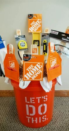 an orange bucket filled with cleaning supplies on top of a carpeted floor next to a wall