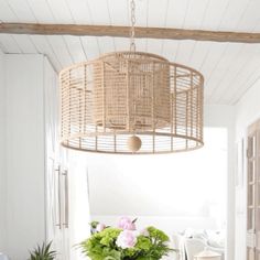 a dining room table with chairs and a basket hanging from the ceiling