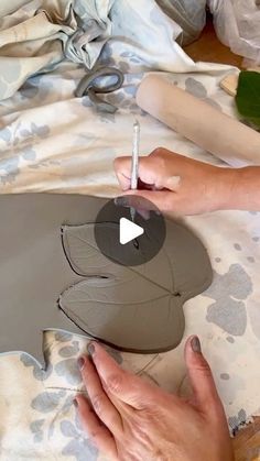 someone is making a vase out of clay and paper maching it with a pen