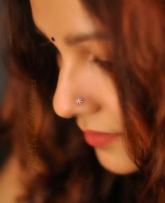 a close up of a person wearing a nose ring with a diamond in the middle