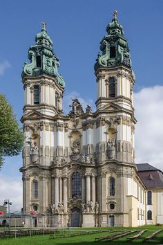 an old building with two towers and statues on top