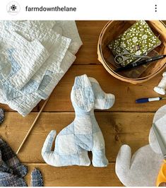 a wooden table topped with different types of cloths and sewing supplies on top of it