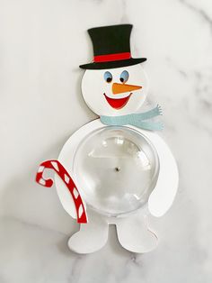 a paper snowman holding a candy cane