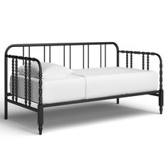 a black metal daybed with white sheets on it's sides and back rails