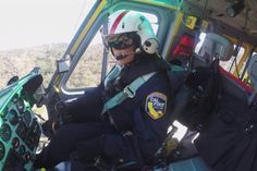 a pilot sitting in the cockpit of a helicopter