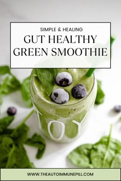 green smoothie with blueberries and spinach leaves in a glass on a white surface