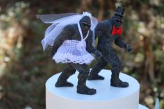 two gorilla figurines dressed up as bride and groom on top of a cake