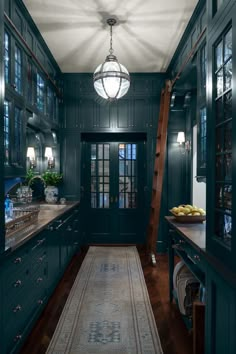 a kitchen with green painted walls and wooden floors, along with an area rug on the floor