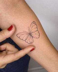 a woman's arm with a butterfly tattoo on the left side of her arm