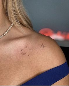 the back of a woman's shoulder with two stars and a crescent on it