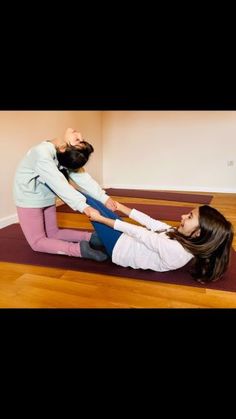 two people are doing yoga on the floor