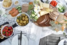 a table topped with plates and bowls filled with different types of food next to utensils