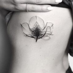 a woman's stomach with a flower tattoo on it