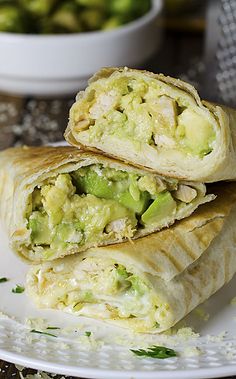 two burritos stacked on top of each other with broccoli in the background