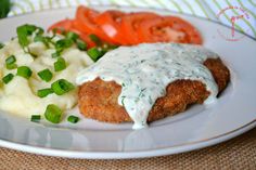 a white plate topped with meat covered in gravy and veggies