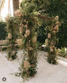 an outdoor wedding ceremony with flowers and greenery