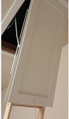 an overhead view of a kitchen cabinet with the door partially open and wires attached to it