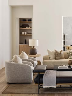 a living room filled with lots of furniture next to a wall mounted painting on the wall