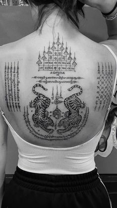 the back of a woman's shoulder with tattoos on it