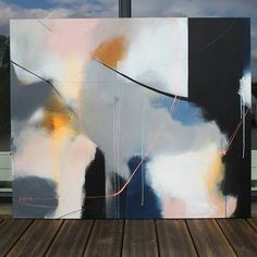 an abstract painting sitting on top of a wooden floor