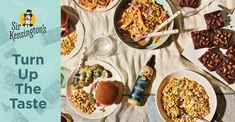 a table topped with lots of food next to a bottle of beer and some forks