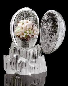 a vase filled with flowers sitting on top of a black table next to a mirror