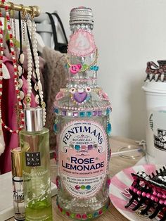 a bottle of perfume sitting on top of a wooden table next to other jewelry items