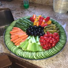 a platter filled with vegetables on top of a kitchen counter