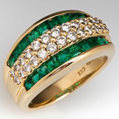 This pretty ring is centered with two-rows of thirteen (13), shared prong set, round brilliant cut diamonds. The diamonds are bordered to each side by a row of ten (10), channel set, square step cut natural emeralds. The ring measures 10.9mm at the top, rises 5.8mm above the finger, tapering to 3.8mm wide and 1.1mm thick at the base of the shank. It is currently a size 6.75. Emerald Diamond Band, Pretty Ring, Diamond Band Ring, Step Cut, Diamond Rings Bands, Channel Set, Pretty Rings, Diamond Band, Natural Emerald