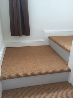 a set of stairs leading up to a window with curtains on the windowsills