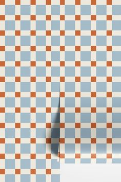 an orange and blue checkered wallpaper with a hole in the middle