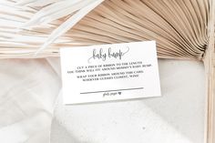 a close up of a piece of paper on a table with a palm frond