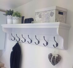 there is a coat rack on the wall with hearts hanging from it's hooks