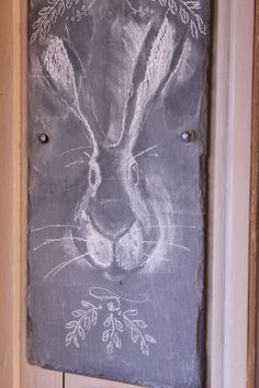 a chalkboard drawing of a rabbit on the front door with leaves and branches around it