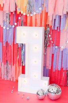 the letter i is surrounded by streamers and confetti on pink flooring