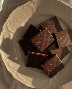 five pieces of chocolate sitting on top of a white plate