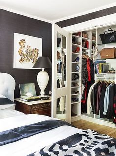 an image of a bedroom with closets and clothes on the shelves in front of it