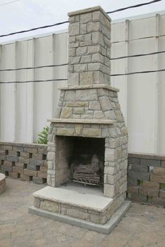 an outdoor fireplace in the middle of a patio