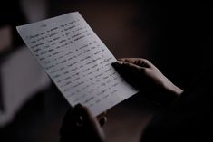 a person holding a piece of paper with writing on it