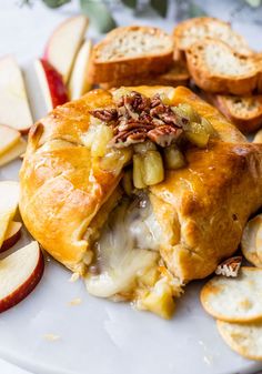 an apple pie on a plate with sliced apples