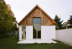 a white house sitting on top of a lush green field