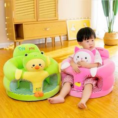 two children sitting on bean bags in the middle of a room with wooden flooring