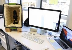 two computers are sitting on a desk in an office