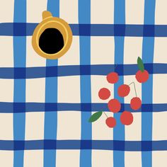 a blue and white checkered table cloth with cherries on it, next to a cup of coffee